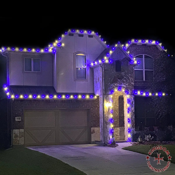 House exterior with blue and yellow string lights on a dark night