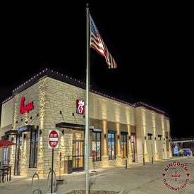Burger King restaurant exterior at night with American flag and Kingdom Christmas Lights logo.