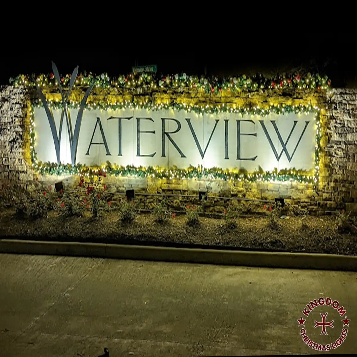 Decorative sign with 'WATERVIEW' text surrounded by lights and plants at night.