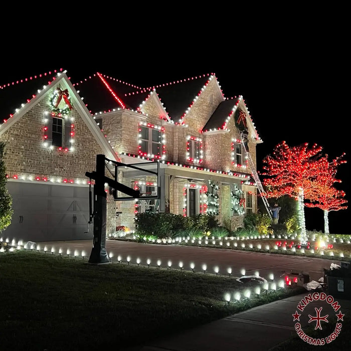 A house decorated with Christmas lights featuring a candy cane pattern with red and white stripes.