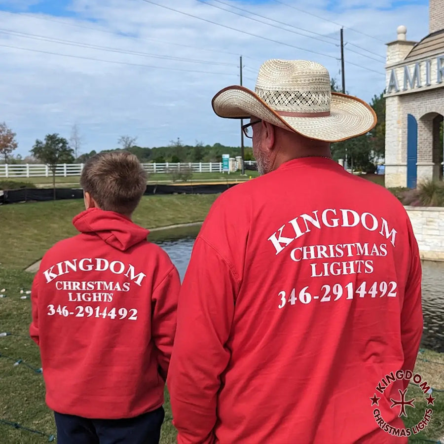 Two people wearing red shirts with 'Kingdom Christmas Lights' branding and contact information.