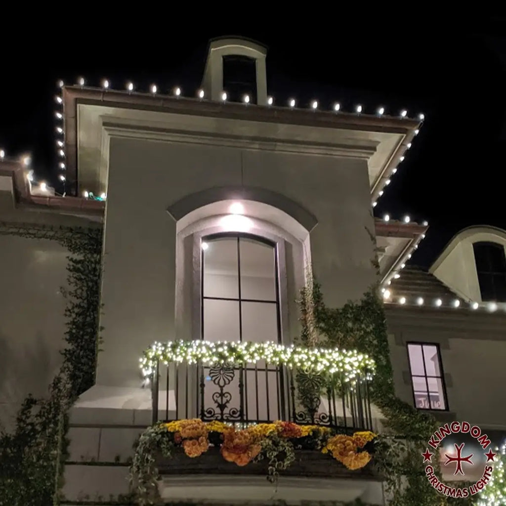 Decorative lights on a building facade with flowers and a visible brand logo.