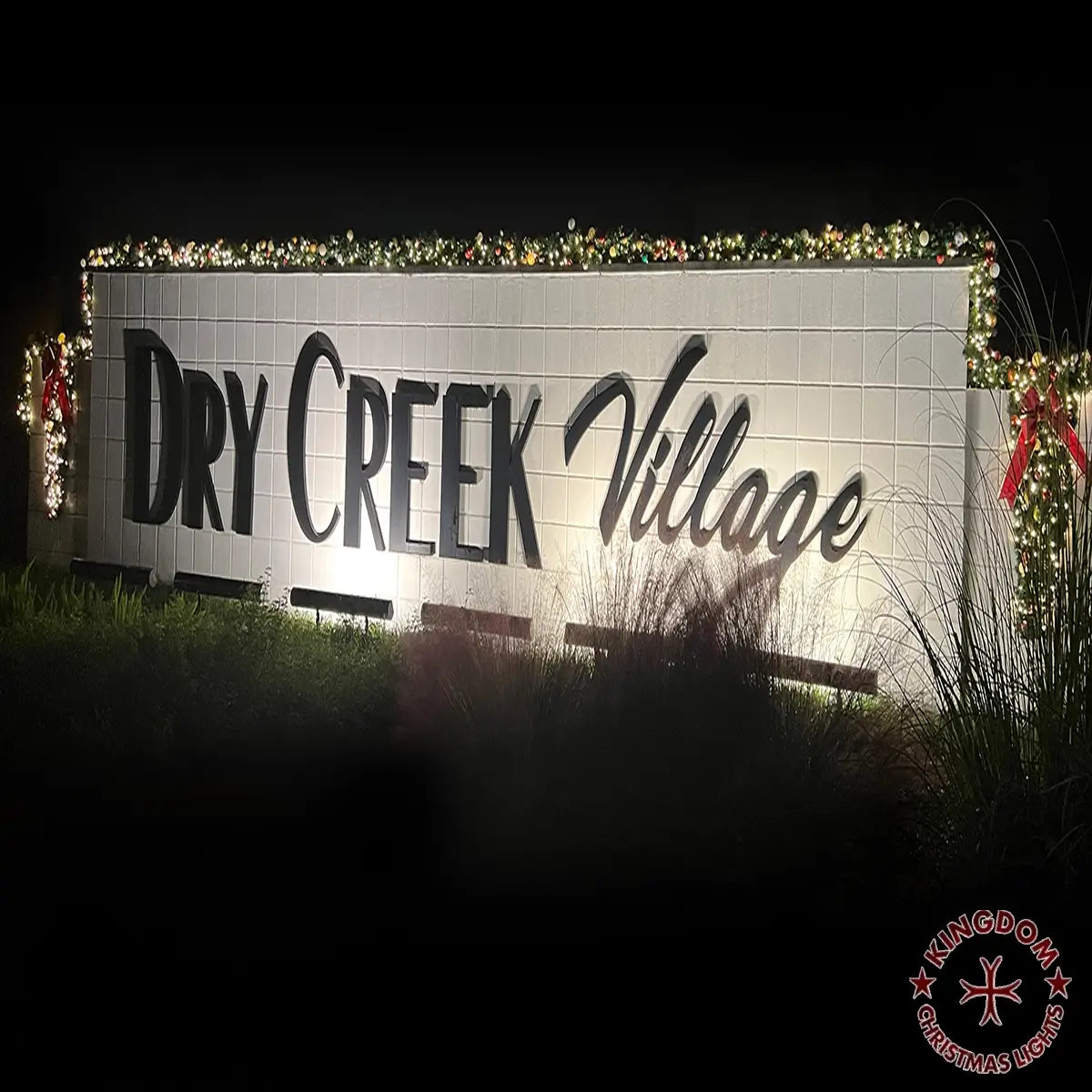 Greater Houston community entrance decorated with illuminated holiday greenery