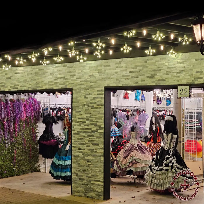 Display of dresses in a store with decorative lights on the exterior.