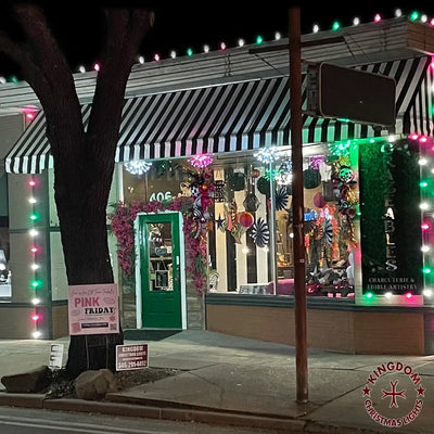 Storefront with striped awning and Christmas decorations at night