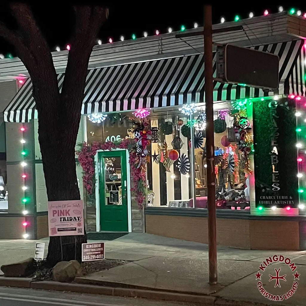 Storefront with striped awning and Christmas decorations at night