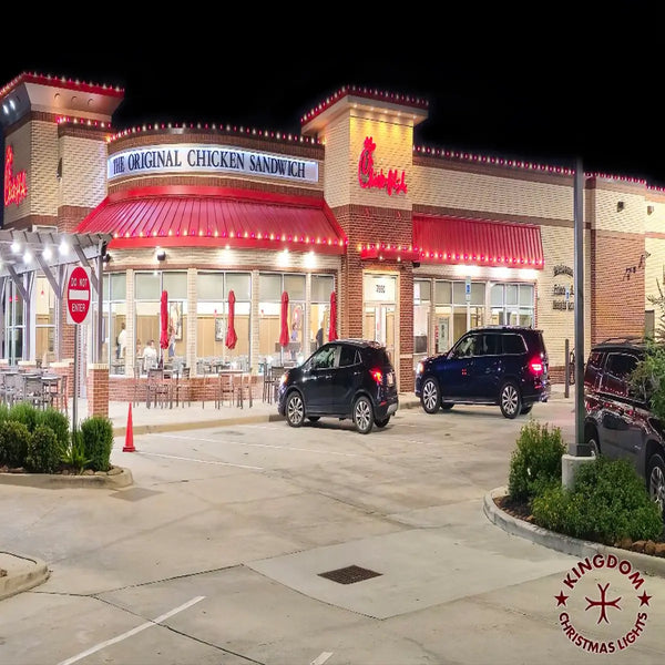 Fast food restaurant exterior with cars parked outside at night