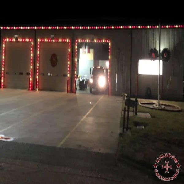 Garage with open doors lit by Christmas lights, vehicle inside