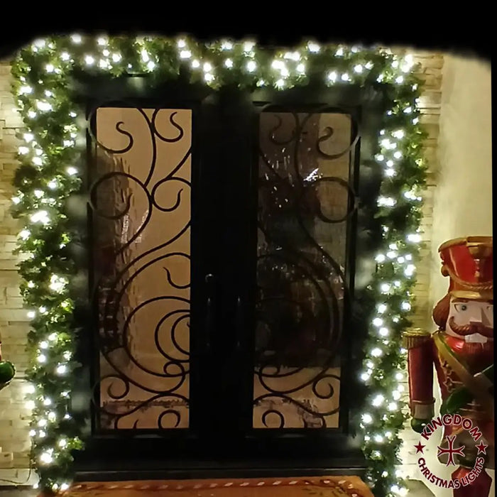 Decorative wreath with lights around a door, featuring a Christmas theme.
