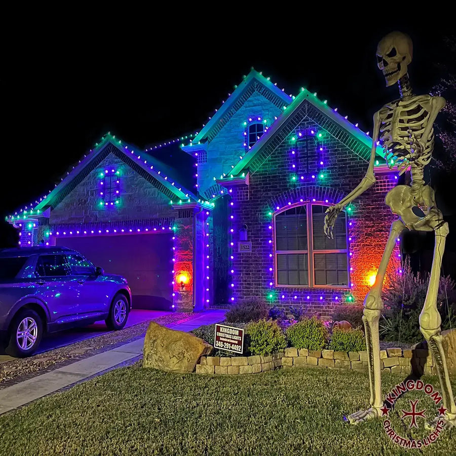 House decorated with colorful lights and a skeleton figure on a Halloween-themed lawn.