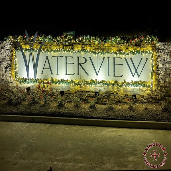 Decorative sign with 'WATERVIEW' text surrounded by lights and plants at night.