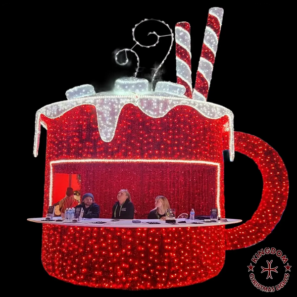 Decorative lighted hot chocolate mug with candy cane on a black background