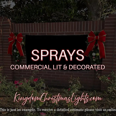 Commercial lit and decorated sign with red bows on a brick wall, featuring 'Sprays' and 'Kingdom Christmas Lights' branding.