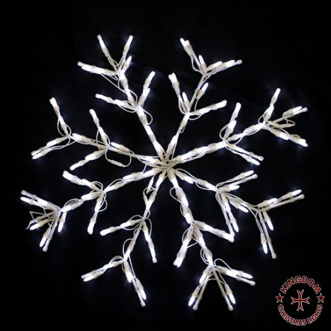 Decorative light snowflake on a black background with Kingdom Christmas logo.