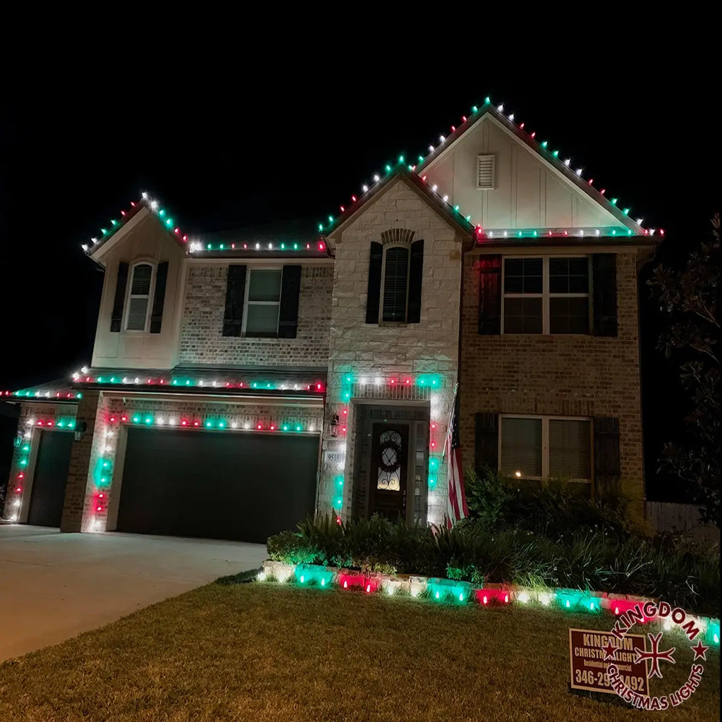 Two-story house decorated with Christmas lights on a dark night.