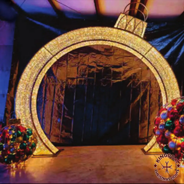 Decorative arch with Christmas lights and ornaments on a stage.