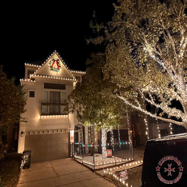 House decorated with Christmas lights and wreath at night